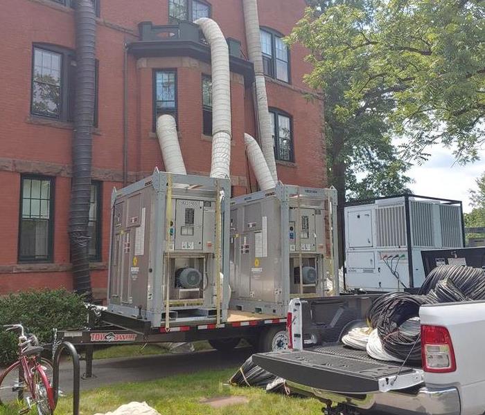 Water removal equipment with white tubes going into a building