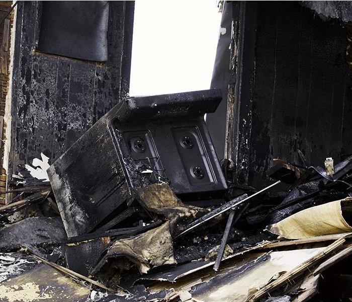 kitchen with stove and walls burned and charred